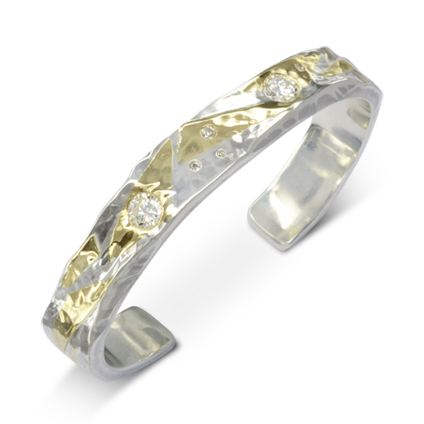 A hammered silver and gold cuff bangle with a rectangular profile flush set with diamonds