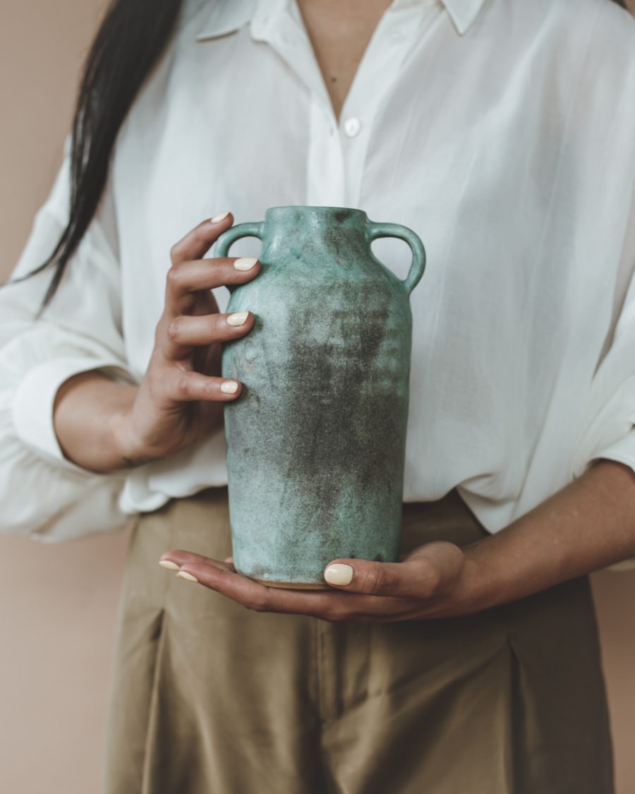 Hand thrown ceramic vase resting on hand