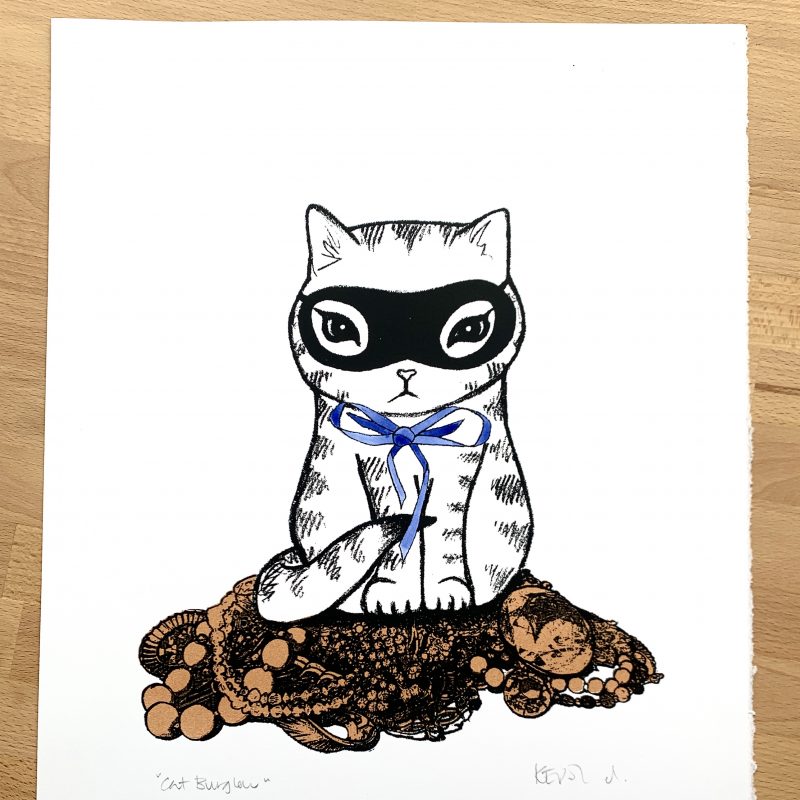 A screenprint: A masked kitten with a blue bow sits atop a pile of copper coloured jewellery