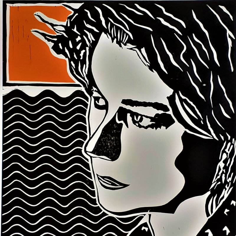 Bridget faces left. Behind her is two blocks of vibrant orange and a middle section of a waved pattern in black and white.  She is captured in black, white and grey tones before a background divided into three horizontal sections. 