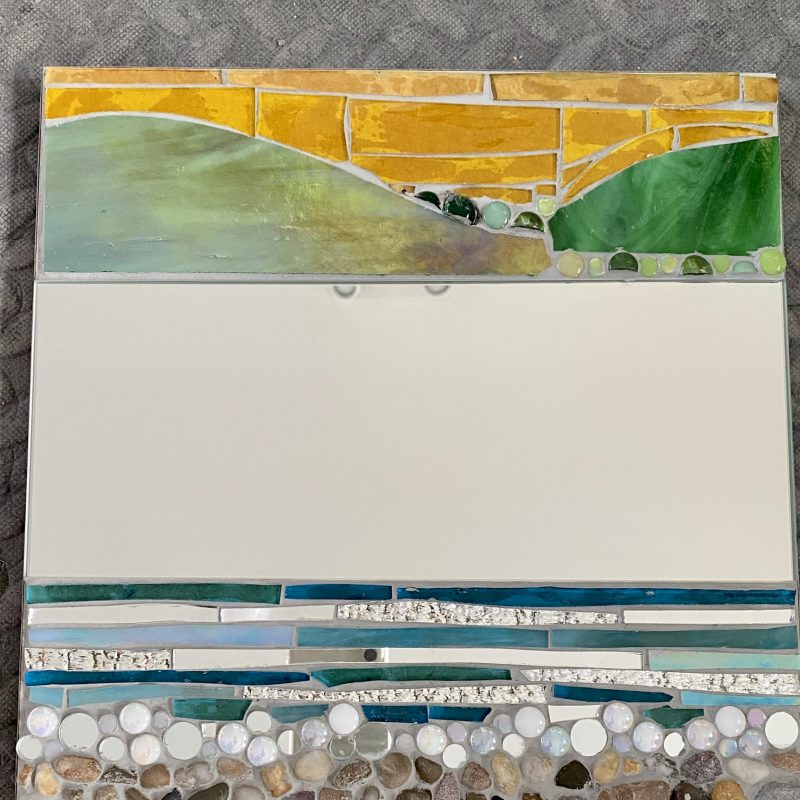 Mirror surrounded by glass mosaic of Downs and beach
