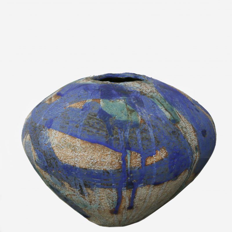 a textured earthenware rounded vessel, with a small hole, with a part painted blue glaze and  