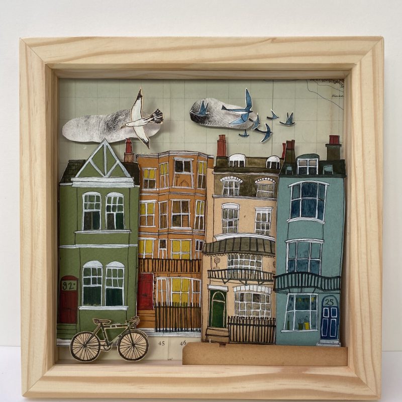 Drypoint etching of a Brighton street scene capturing an eclectic mix of coloured houses. Cut and collaged into a wooden box frame to create a 3D effect.