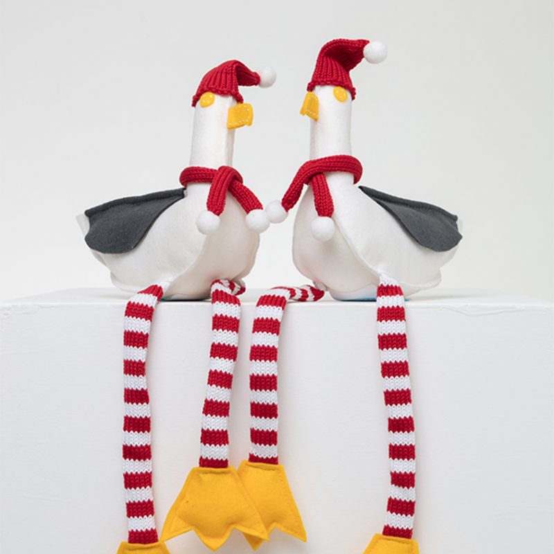 Felt seagulls with red and white knitted striped legs, wearing Santa hats and scarves