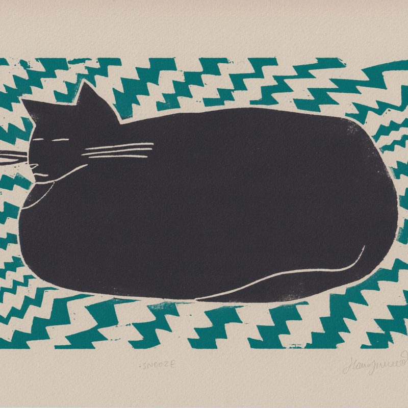 Woodcut print of a black cat sleeping on a green rug with zig zag pattern