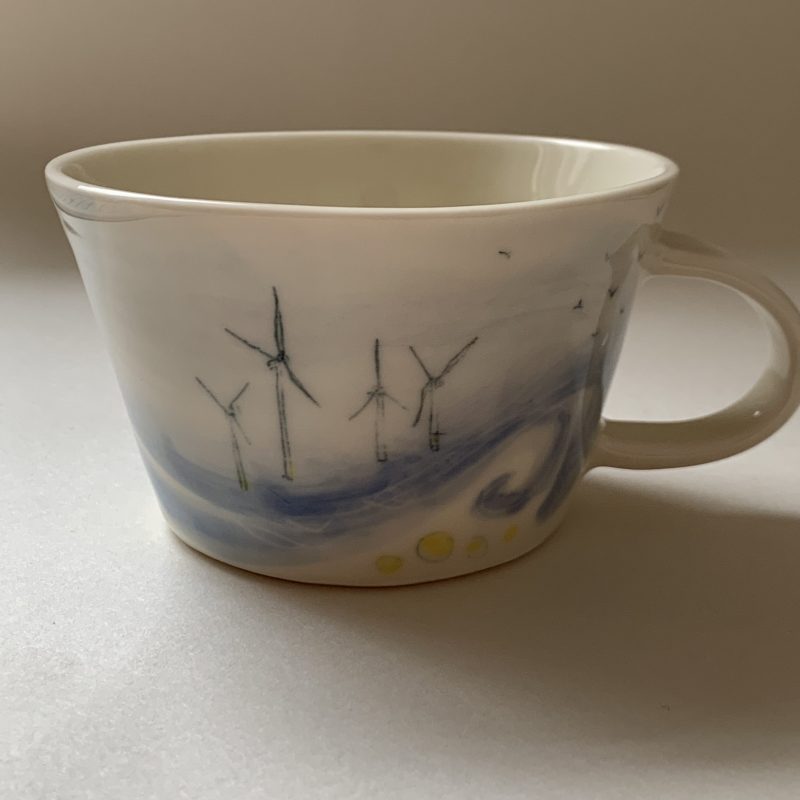 This unique porcelain mug is hand painted with images of the Rampion Wind Turbines  When making these illustrative ceramic pieces in my Brighton studio I work with porcelain. This gives me a smooth canvas for meticulous drawings of the South Downs and coast.  I work form memories and photographs as I hand paint and layer glazes onto my pieces.  This process takes many hours.  Currently I am working on a series of functional ceramic pieces that are inspired by the impact that we have on the land, from  barbed wire fences and pylons, to the Rampion Wind Turbines.  11 cm diameter x 7 cm height