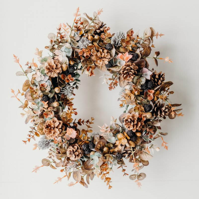 A gorgeous wreath created with browned eucalyptus leaves, pine cones, thistles and blackberries for a true autumnal feel. This wreath is perfect for hanging on the front door or as part of a table centre piece with candles. 