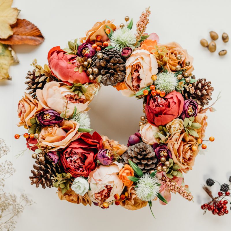 A beautiful, full autumn wreath created with autumnal coloured peonies and roses as well as pine cones and berries. This wreath is perfect for hanging on the front door, as a wall hanging or as part of a table centre piece with candles. 