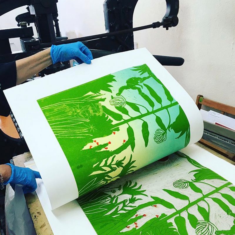 Image of a linocut print being taken from a block