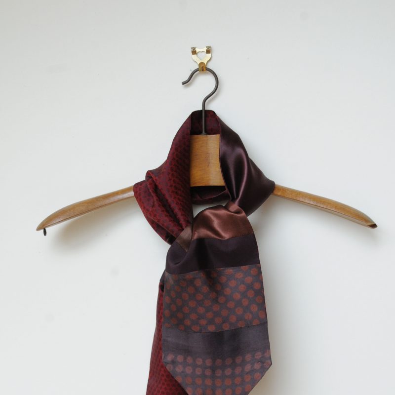 A Tie scarf made from a variety of burgundy fabrics 