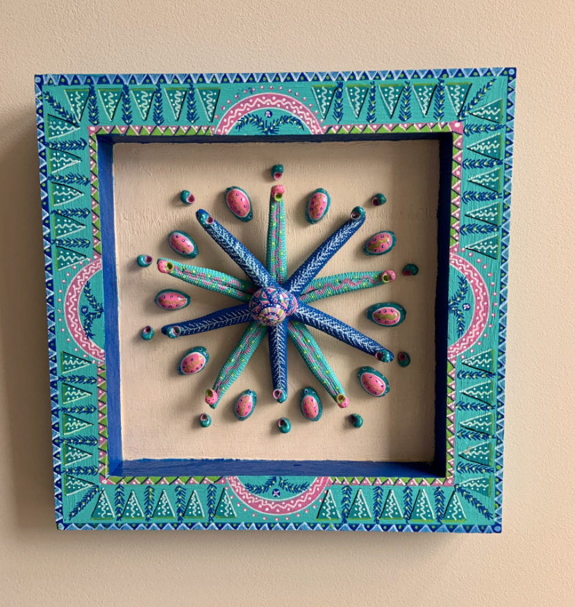 Composition made of 2 fingers starfish and cowrie shells in a decorated frame 