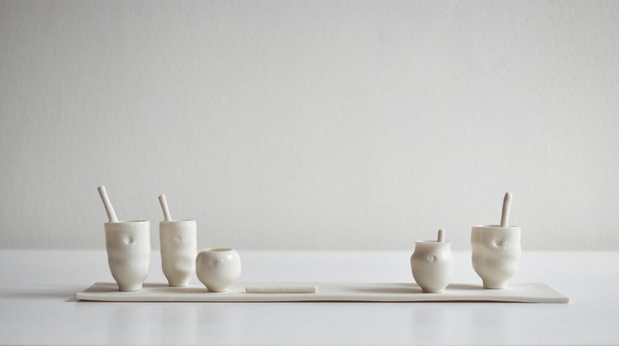Tiny white porcelain vessels on a porcelain slab. Rachel works in black, grey and white porcelain