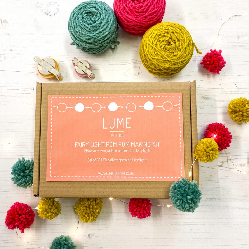DIY craft kit for adults to make colourful pom poms that attach to a string of fairy lights