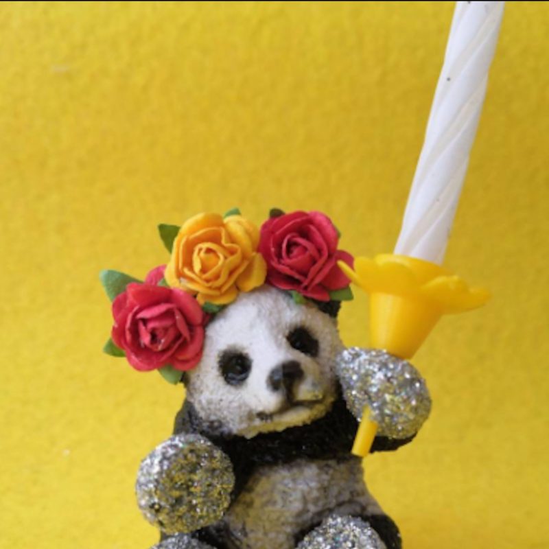 Plastic panda holding a candle