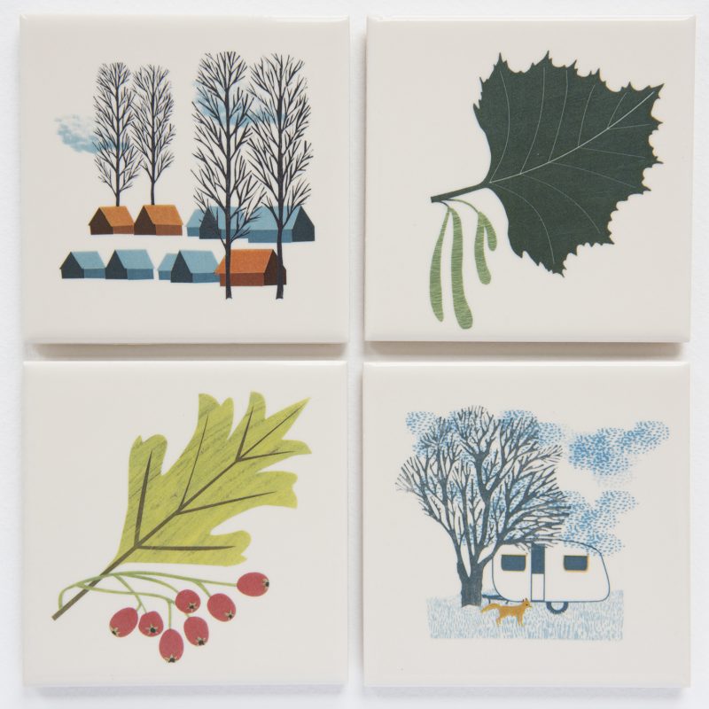 Four ceramic tiles decorated with images of trees and leaves