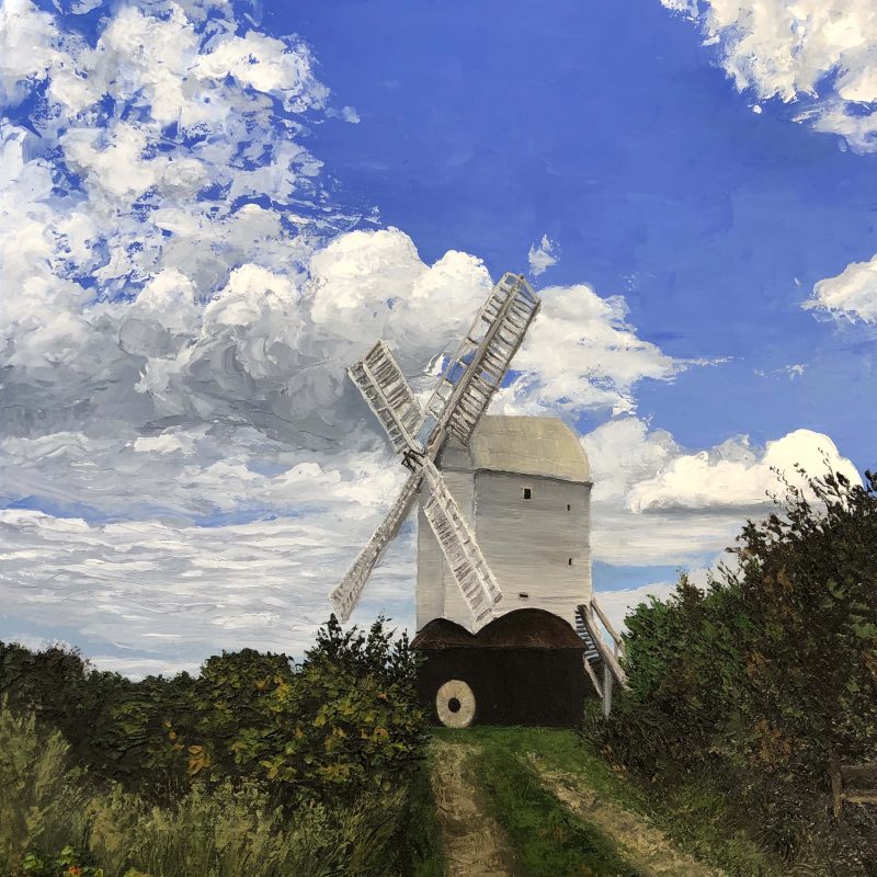 Palette knife painting of the Jill Windmill on a sunny September day. The white textured windmill is surrounded by long grass and green shrubs with orange flowers. A path leads from the windmill towards the foreground. Low clouds surround the windmill with a block of blue sky to the right.