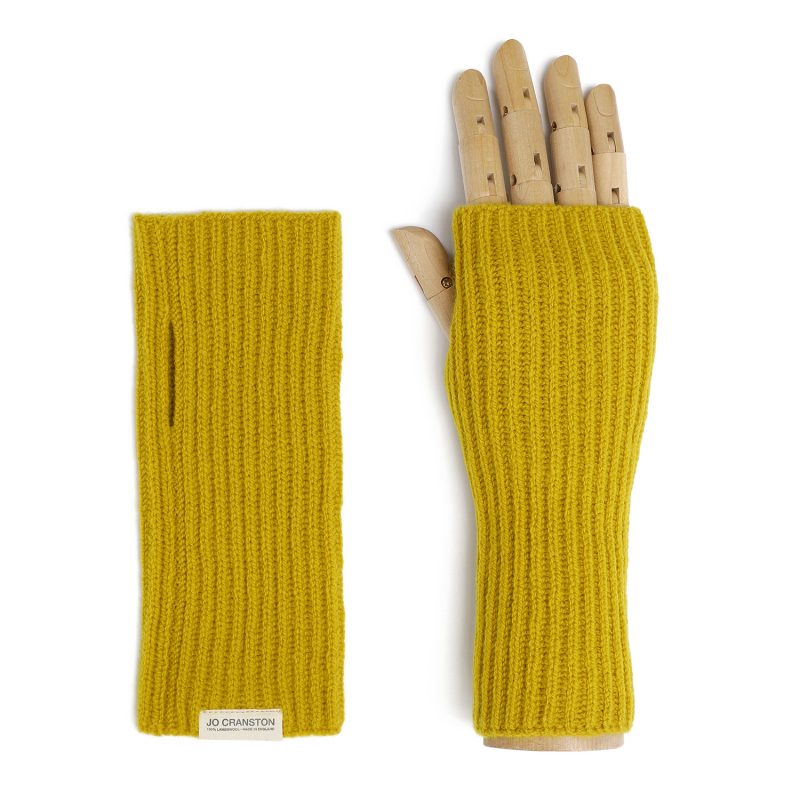 A pair of wambswool fingerless gloves, one lying flat and one on a wooden hand