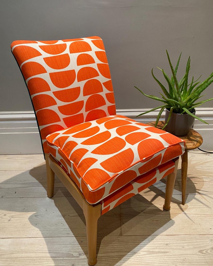 Bright orange modern print fabric used to recover small vintage Parker Knoll chair