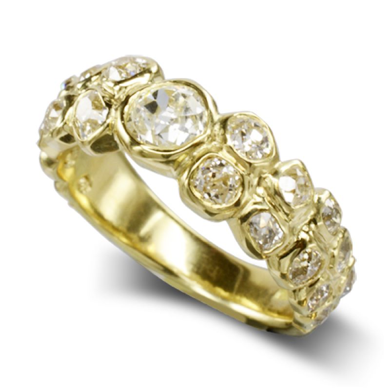 A thick band of gold carved to fit uneven shapes of old cut diamonds, 5-6mm wide