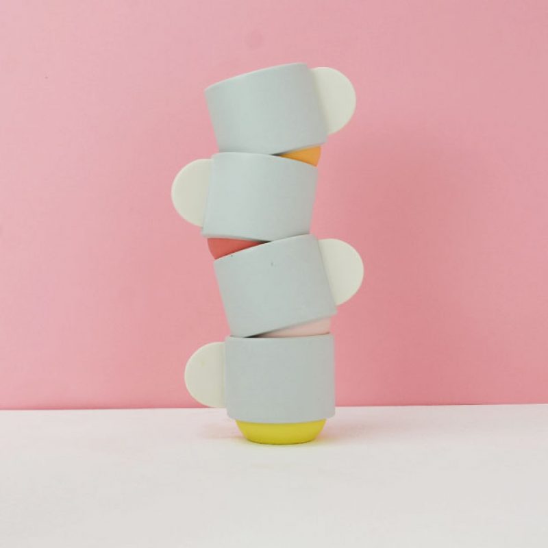 four espresso cups stacked on top of each other with semi circle handles and coloured bases made from porcelain 
