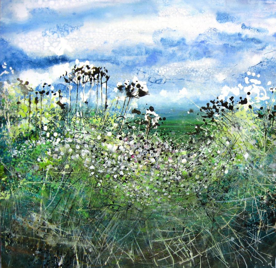 Green hedgerow with strong flower heads against the background of the Downs and Summer Sky 
