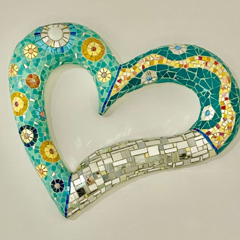 A heart shaped wall piece in relief with textured glass mosaic in silver, gold and red.  Size: 60cm x 60cm 