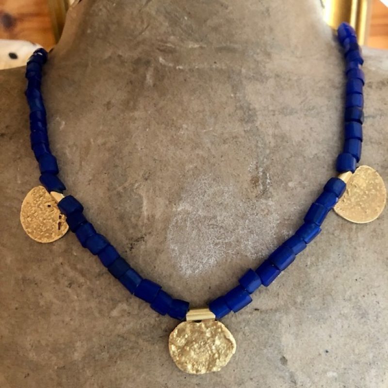 A beautiful necklace of blue stones with gold hanging from it at intervals