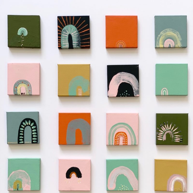 Giclee print poster of 20 mini square canvases on a white background. Each canvas is painted in muted and bright tones with rainbow motifs on each.