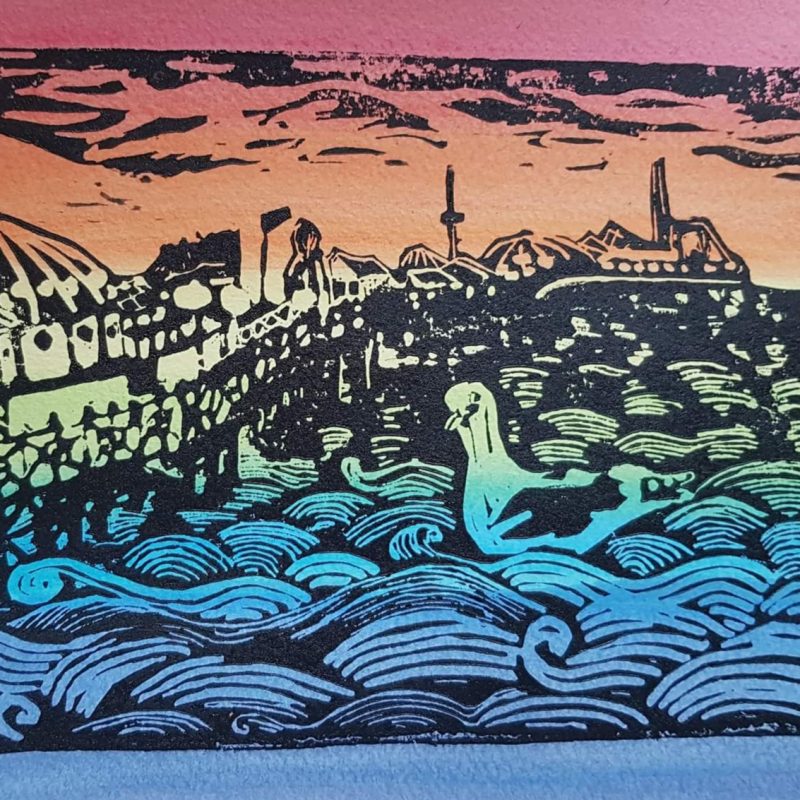 A lino cut of Brighton Pier with Seagull in black line with striped, rainbow background, a card frame surrounds.