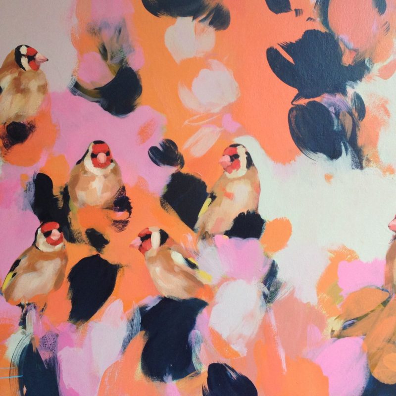 Goldfinches sit in pink and orange.