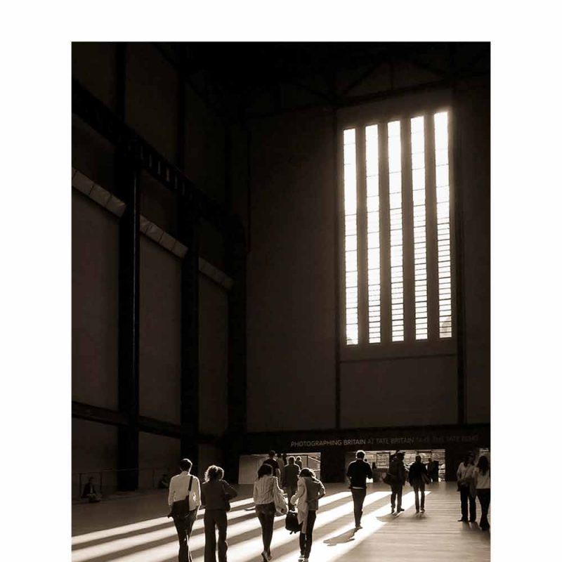 Walking To The Light - Digital Photograph, visitors moving the the light and shadow created by the large window in the Tate Modern Turbine Hall