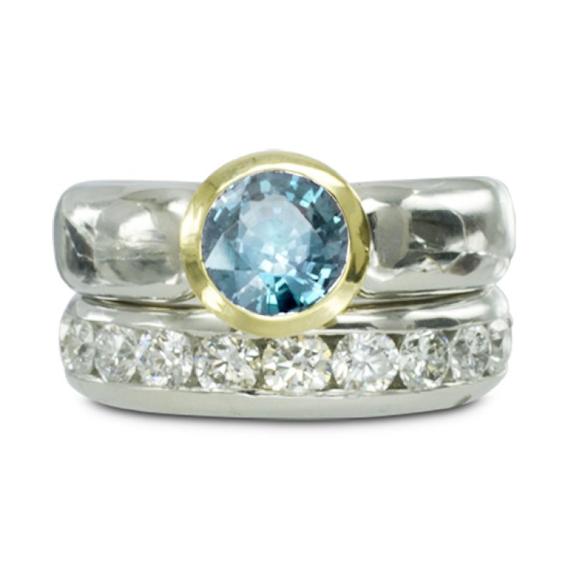 A 6mm round aquamarine in an 18ct yellow gold taper rubover style setting on a 6mm platinum court style band.