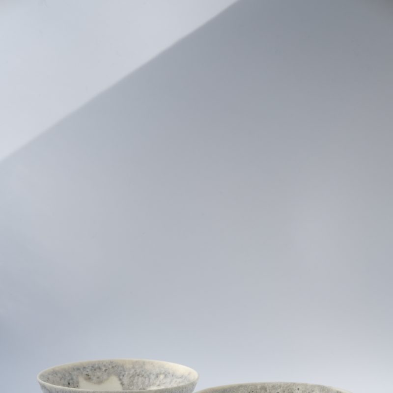 2 beautiful ceramic cups with volcanic-like texturing on the outside.