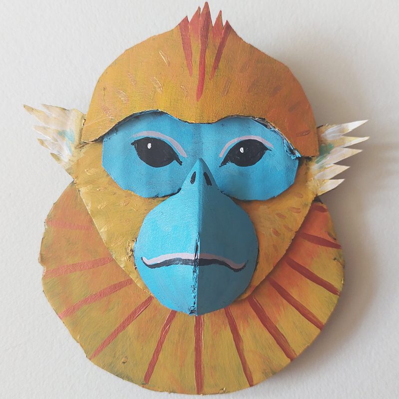 A monkey head made out of cardboard and acrylic paint