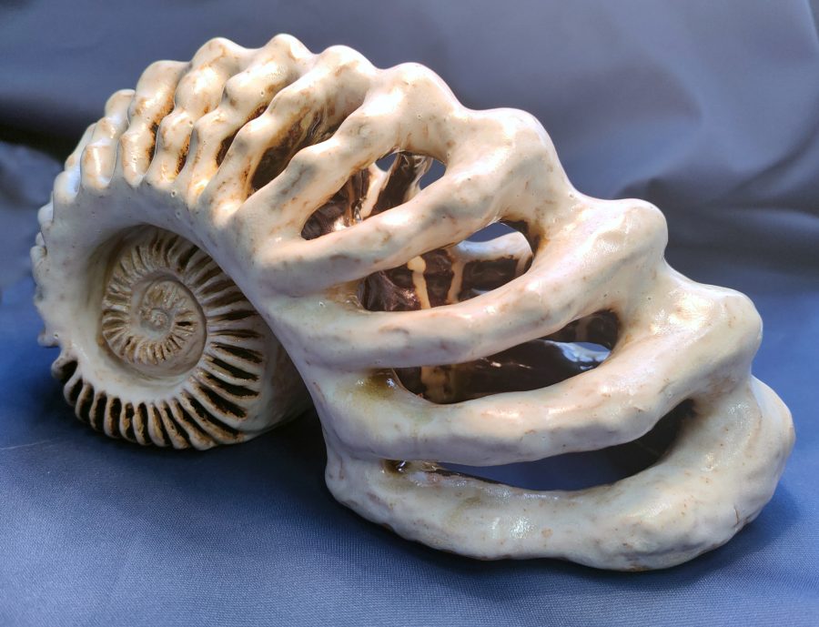 Pale, cream coloured ceramic piece reminiscent of an ammonite