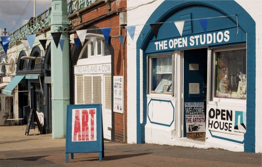 Image of the front of The Open Studios. A blue archway frames the shop with white walls. A sign out the front reads Art