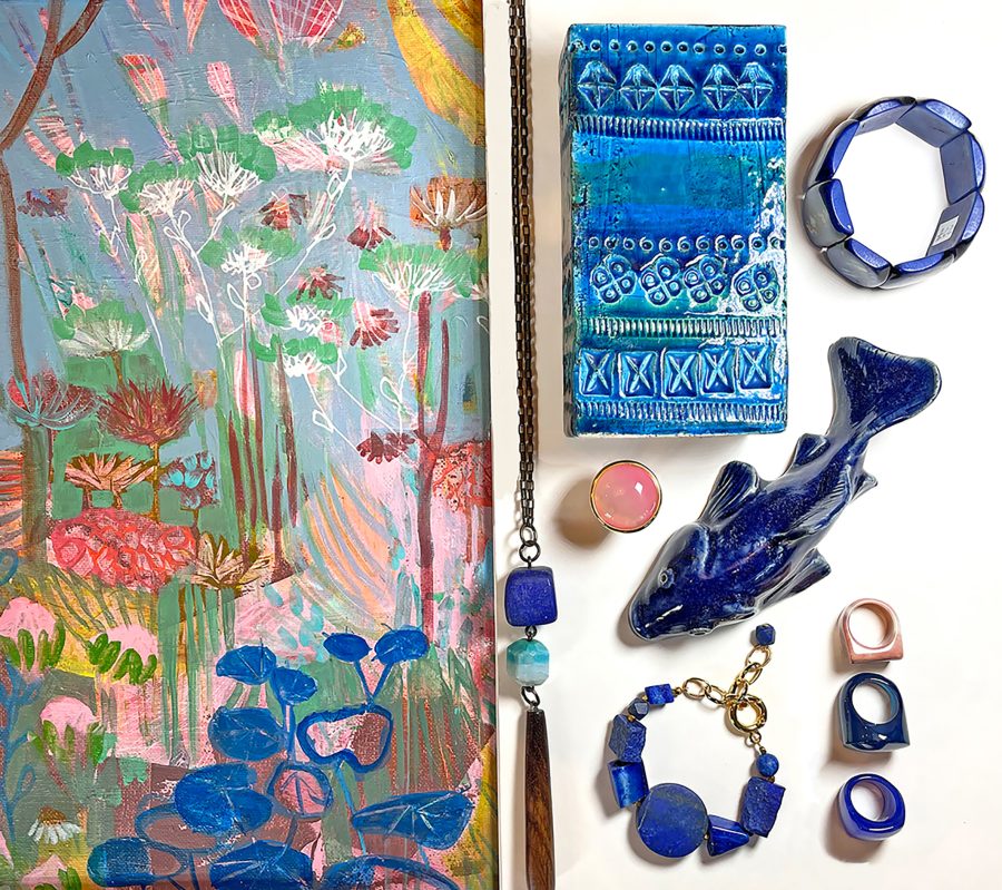 A section of a brightly coloured painting with coordinating ceramic vase, fish and blue and pink jewellery.