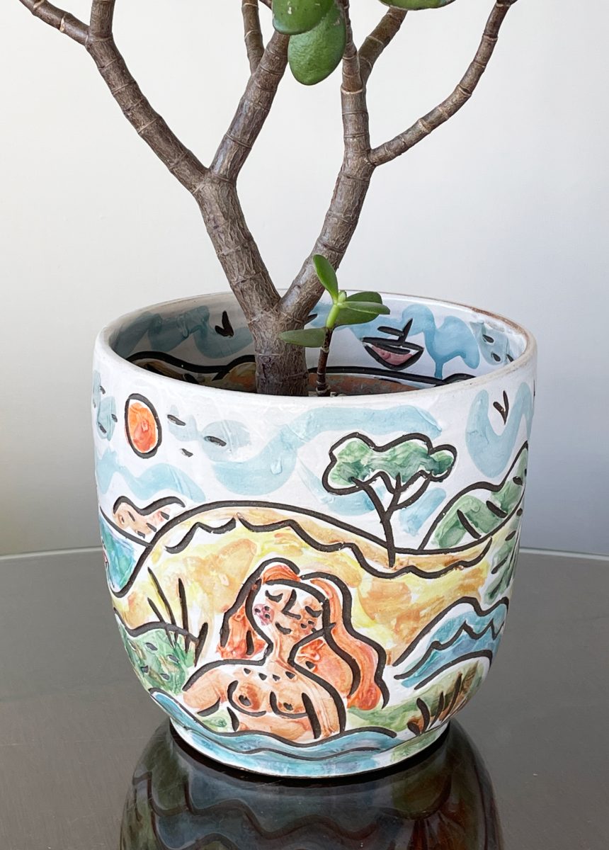 A stoneware planter with a swimmer in a seascape with islands and a boat.