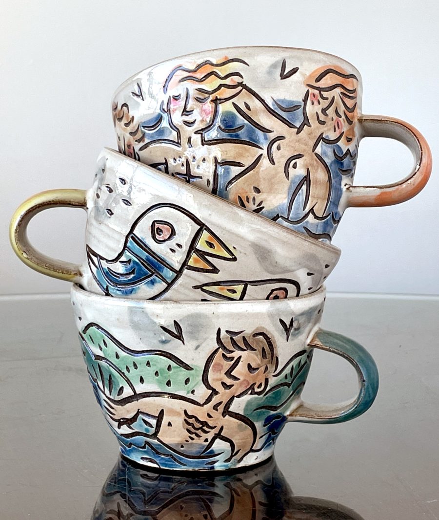 Colourful mugs, decorated with swimmers and seabirds.