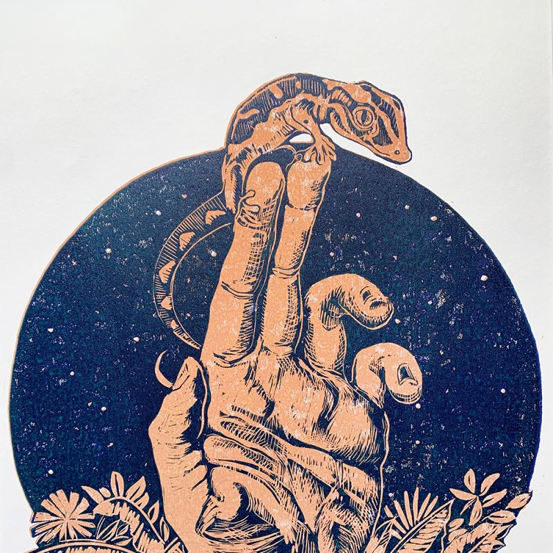 A lino cut reduction of a gecko sitting on human finger tips raised above a jungle landscape in the background.