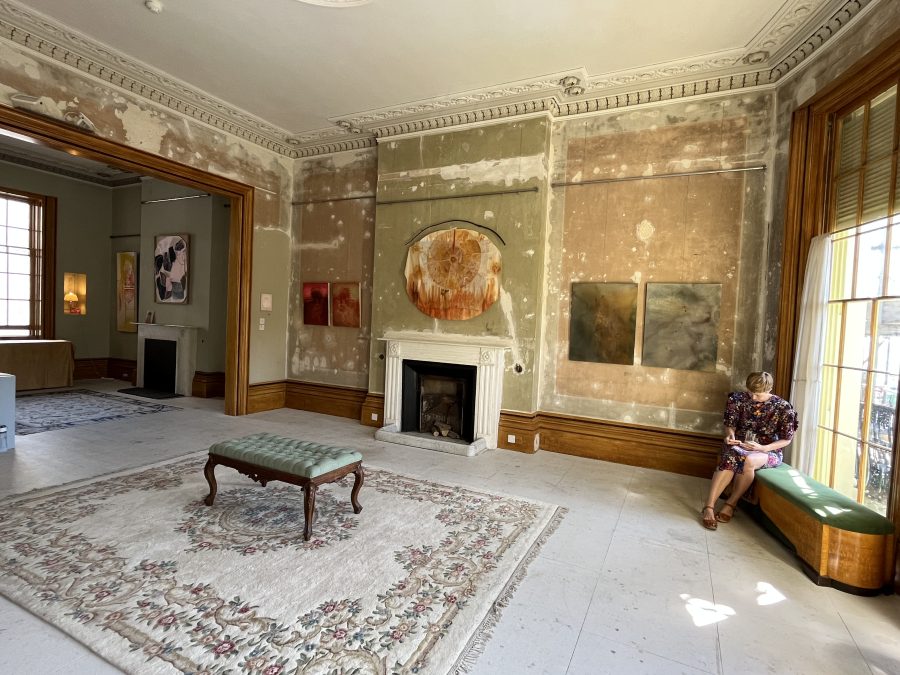 An interior view of paintings hung in the Regency Town House with a woman sitting in the window