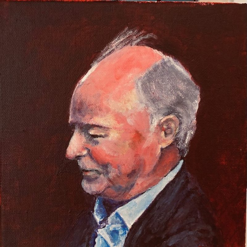 A portrait in profile of an Irish man with thining hair. He is smiling.