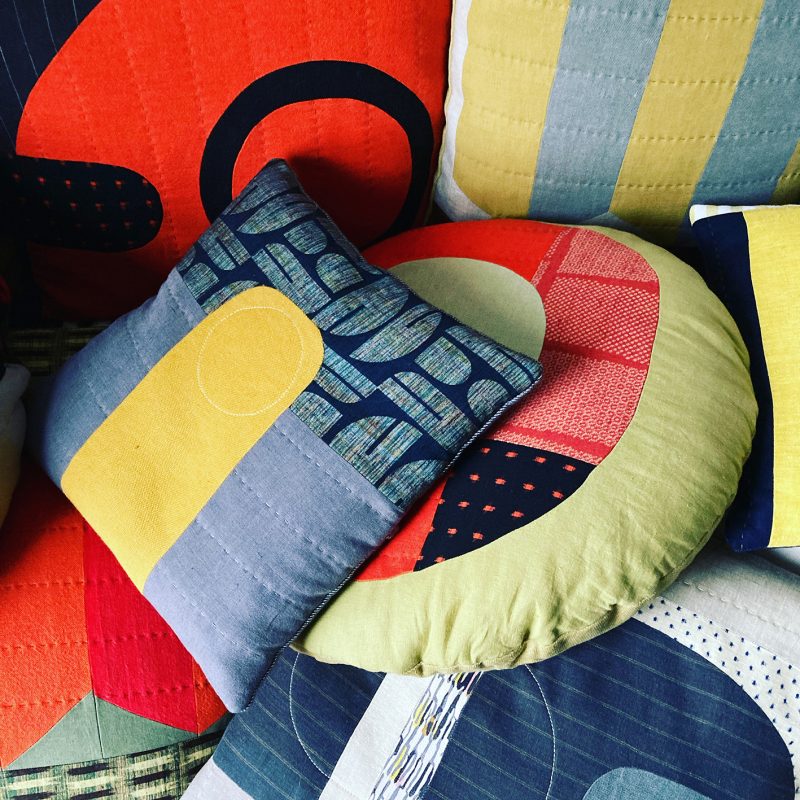 A collection of colourful cushions in bright, graphic shapes