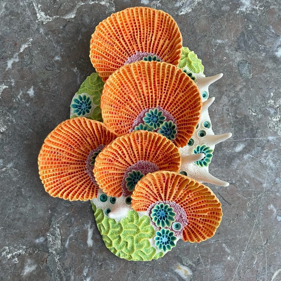 This is fine porcelain sculpted and textured to look like coral, glazed in bright oranges and greens. its a small piece and can be wall hung
