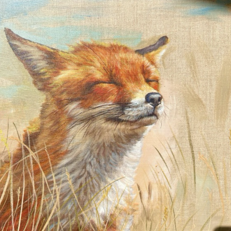 A fox squinting happily into the suns warmth amongst the long golden grass. The fox is detailed and rich in colour against the suggested blue Skys, late summers day, backdrop, leaving parts of the linen canvas showing