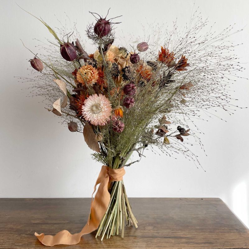 Dried flower bouquet tied with lace in autmnal oranges, voilet and pink