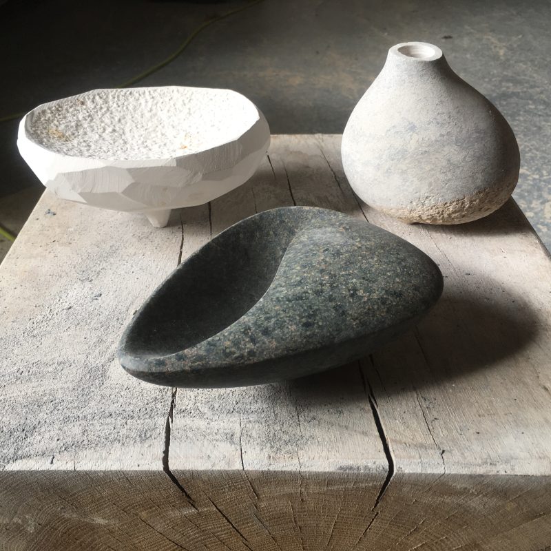 Three hand carved stone vessels - each one about form and not practical. Indoor sculpures