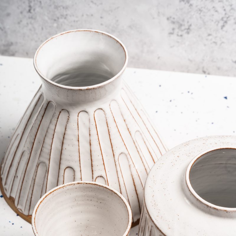 three hand thrown ceramic pots with white glaze and grooved pattern