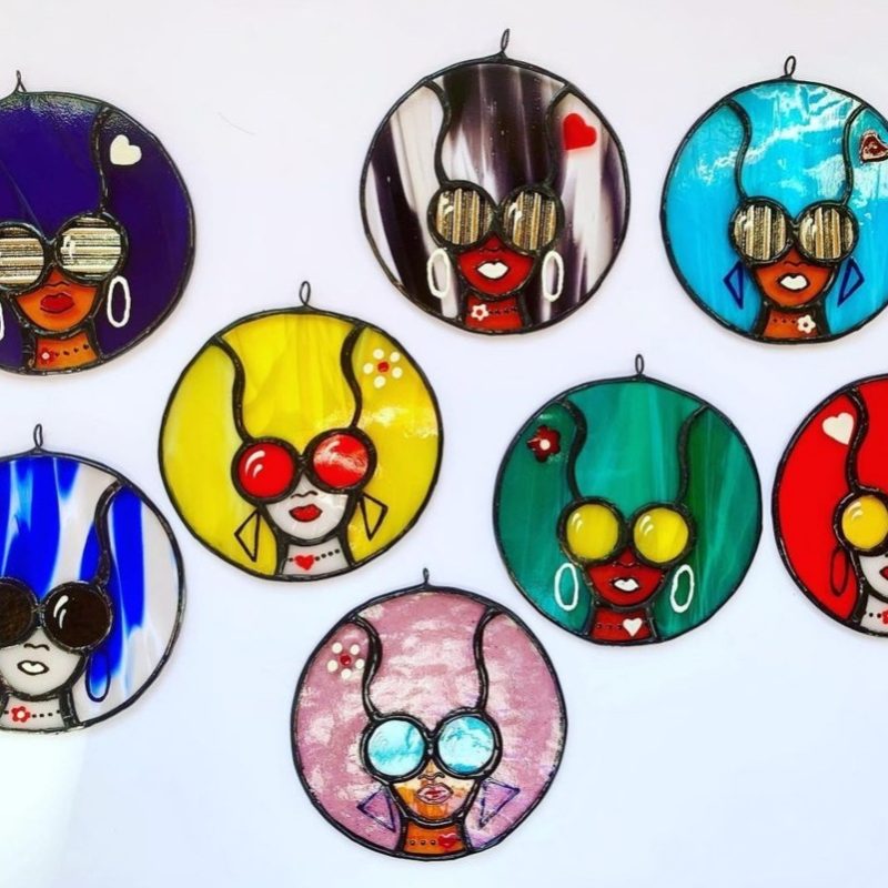 Brightly coloured glass discs of Disco Hair styles with faces wearing sun glasses
