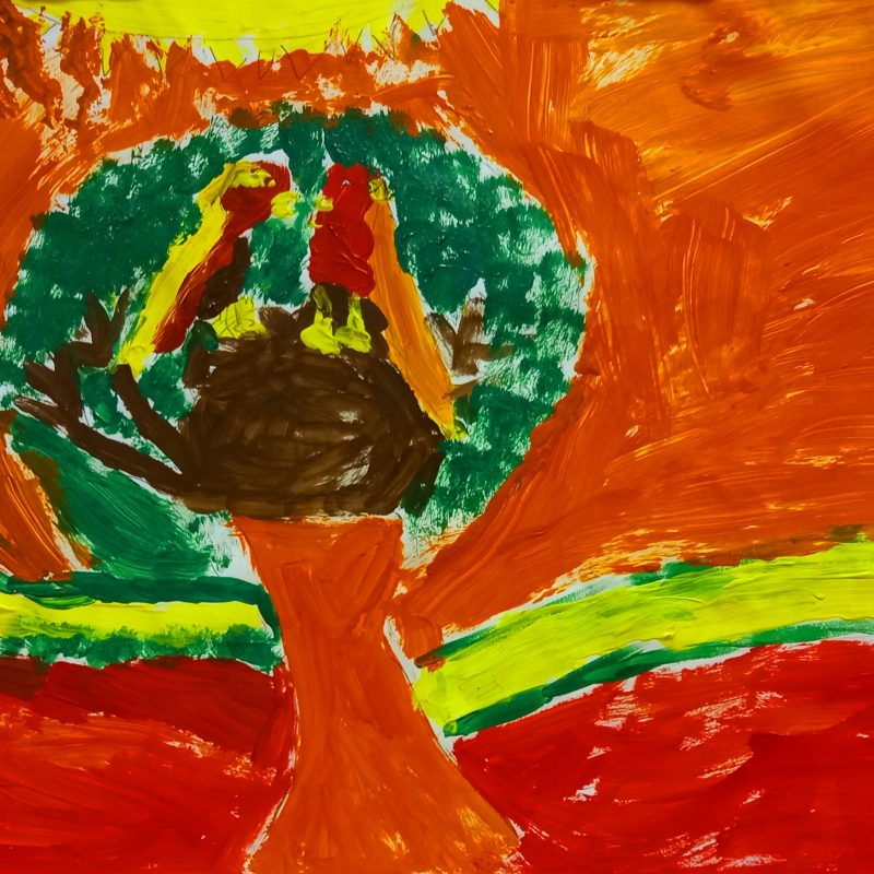 Two lovebirds, one yellow and read and one red and orange, in a green tree with a red and orange background